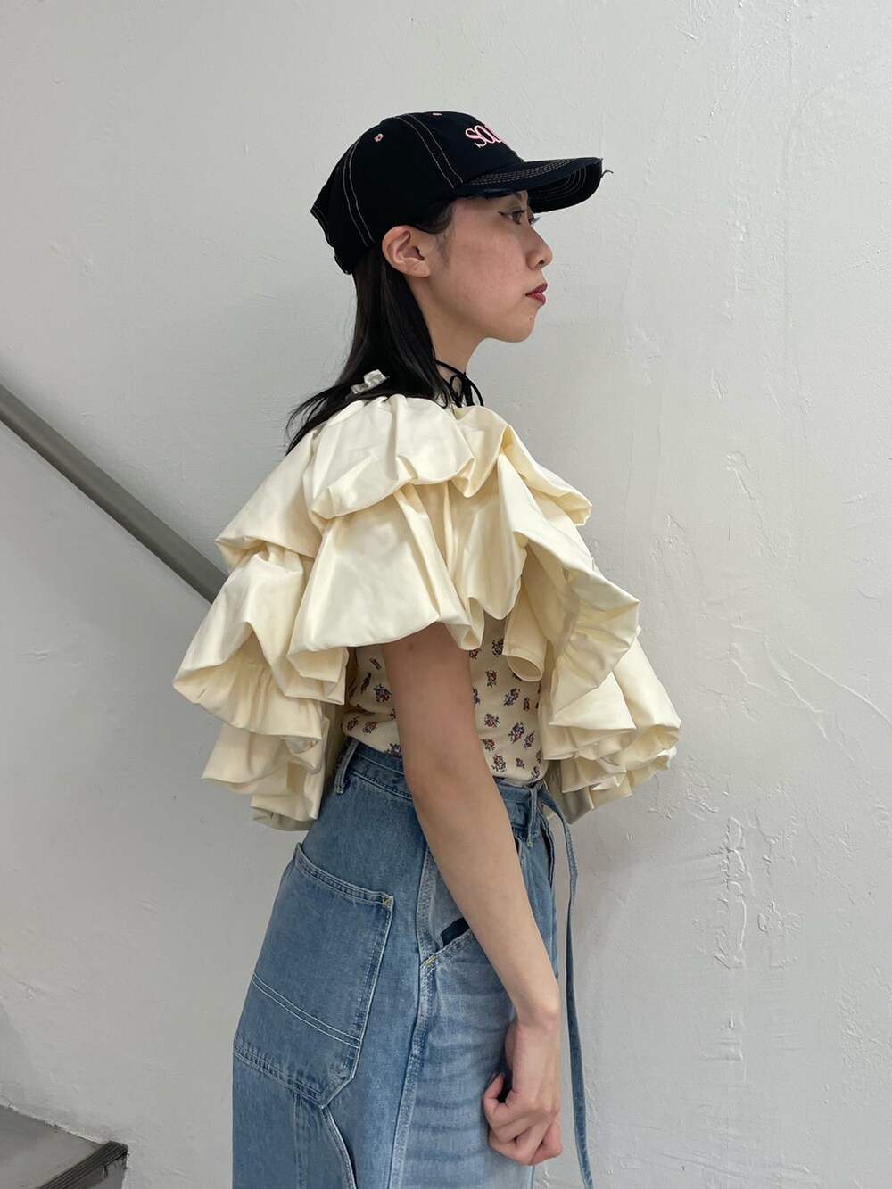 ブルー系のデニムパンツ、ホワイト系のスカート、ホワイト系のTシャツ/カットソーを着用したレディースの春コーディネートの7枚目の写真