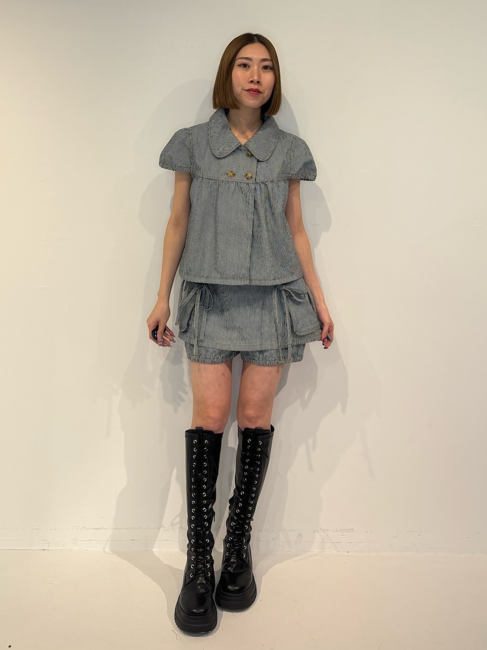 ブラック系のブーツ、ブラック系のデニムパンツ、ブラック系のその他トップスを着用したレディースの冬コーディネートの2枚目の写真