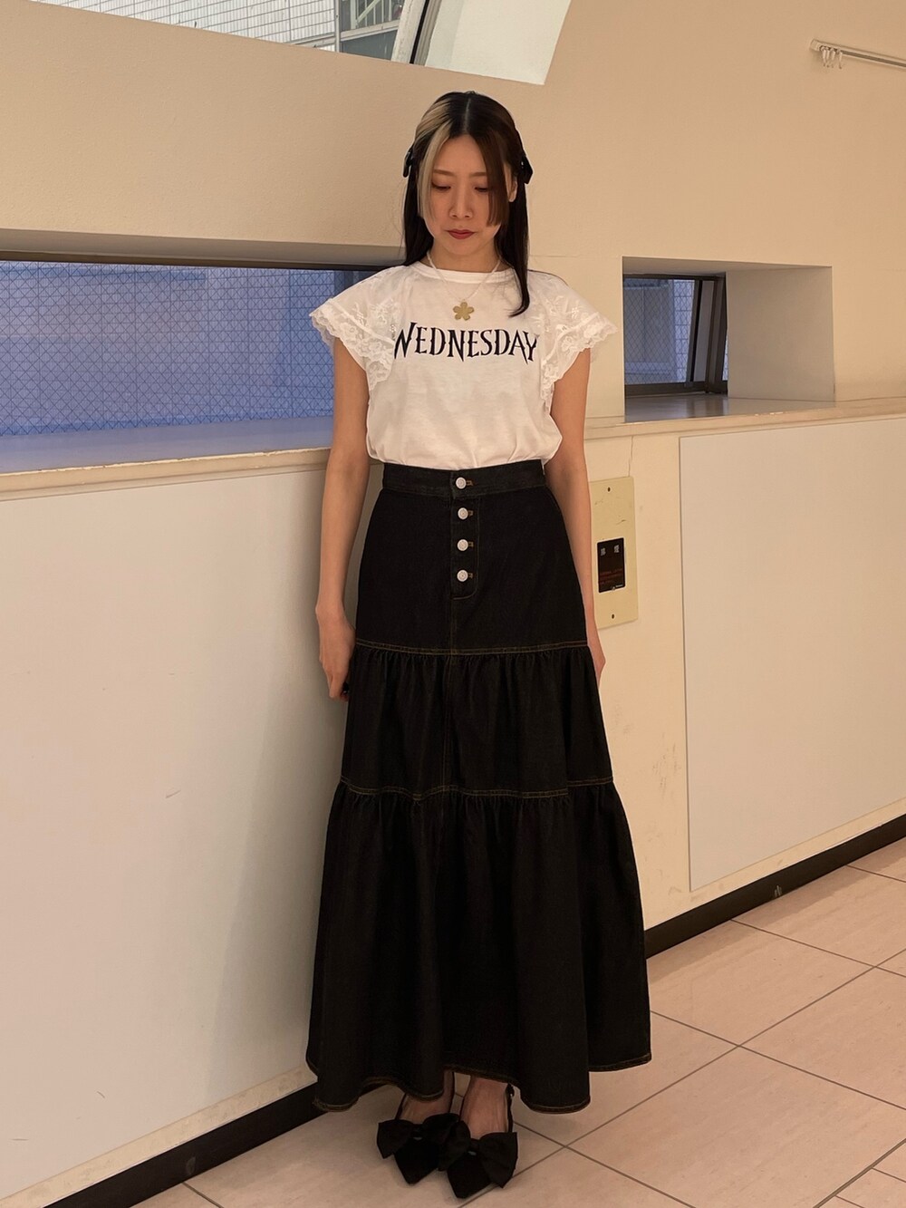 ブラック系のワンピース、ホワイト系のTシャツ/カットソー、ブラック系のパンプスを着用したレディースの春コーディネートの2枚目の写真