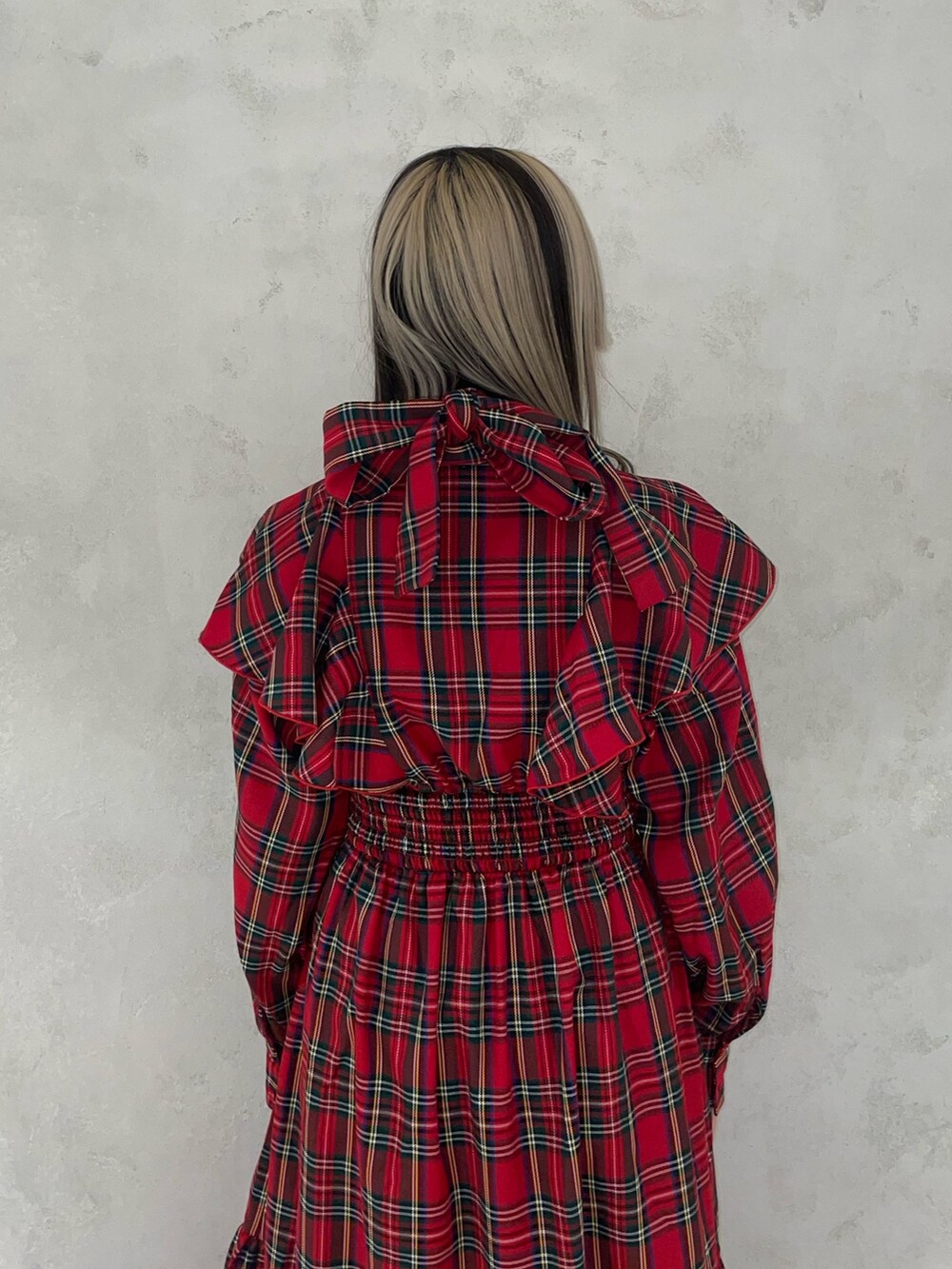 レッド系のワンピース、ゴールド系のネックレスを着用したレディースの冬コーディネートの5枚目の写真