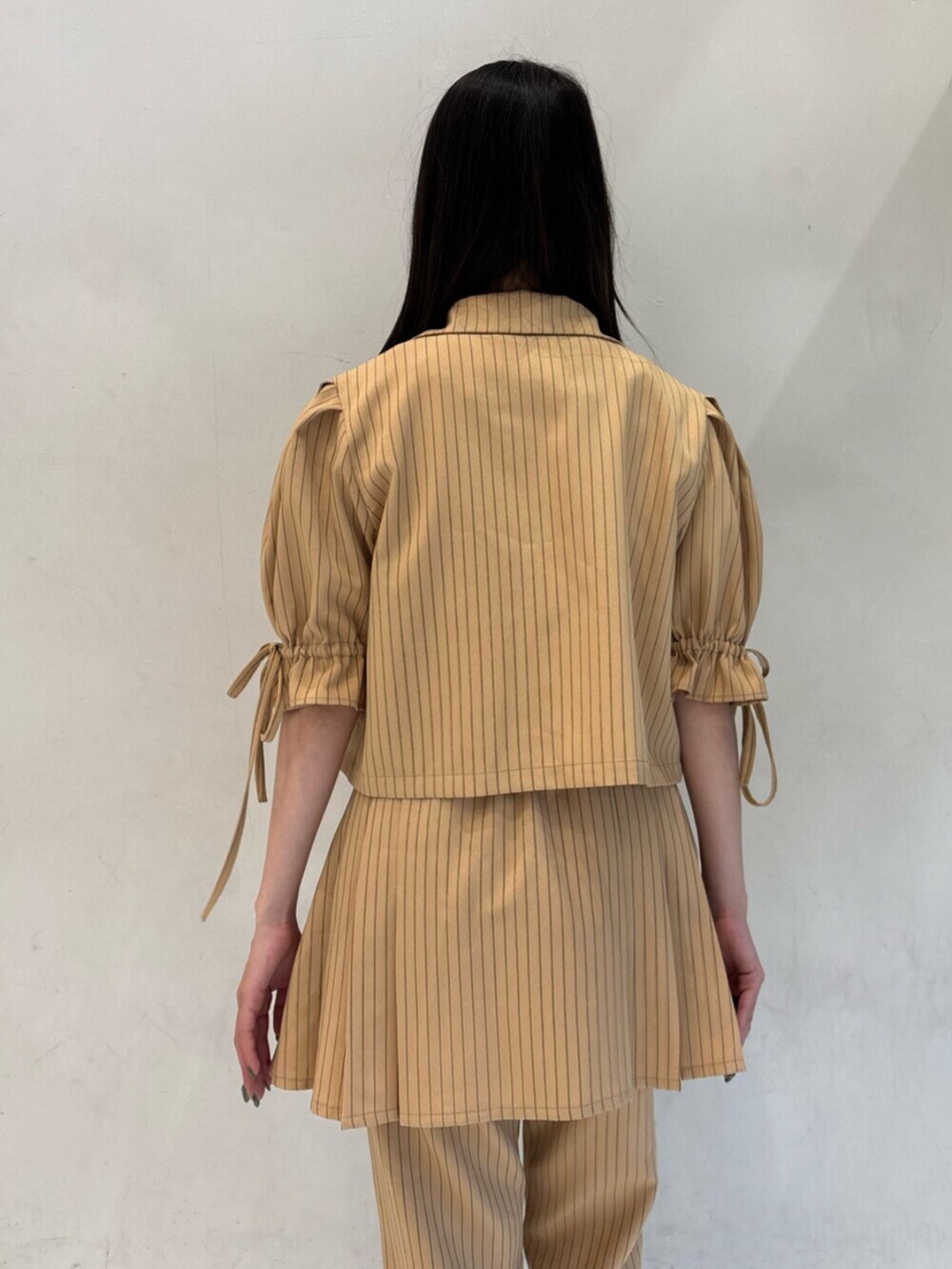 ベージュ系のテーラードジャケット、ベージュ系のその他パンツ、ベージュ系のスカートを着用したレディースの冬コーディネートの8枚目の写真