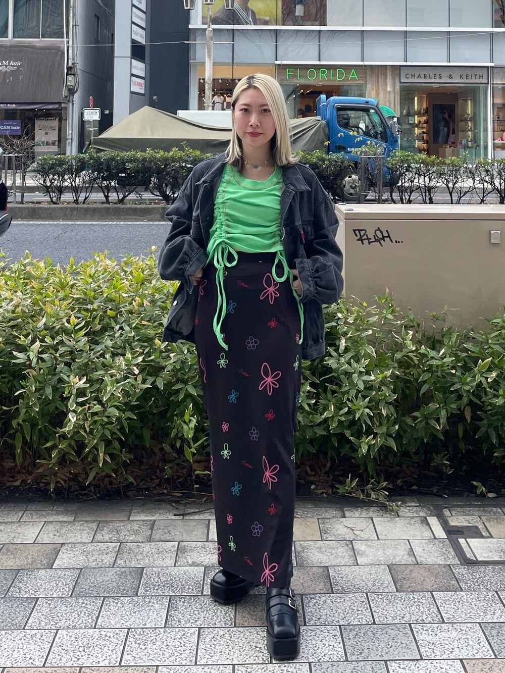 ブラック系のスカート、グリーン系のTシャツ/カットソー、ブラック系のデニムジャケットを着用したレディースの春コーディネートの2枚目の写真