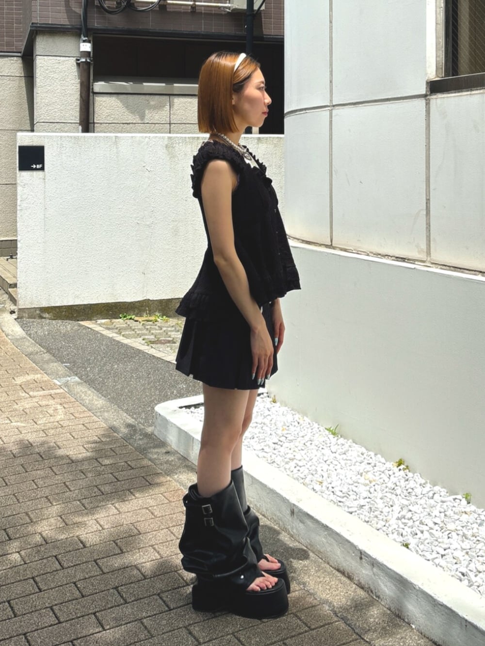 ブラック系のサンダル、ブラック系のシャツ/ブラウス、ブラック系のスカートを着用したレディースの夏コーディネートの3枚目の写真