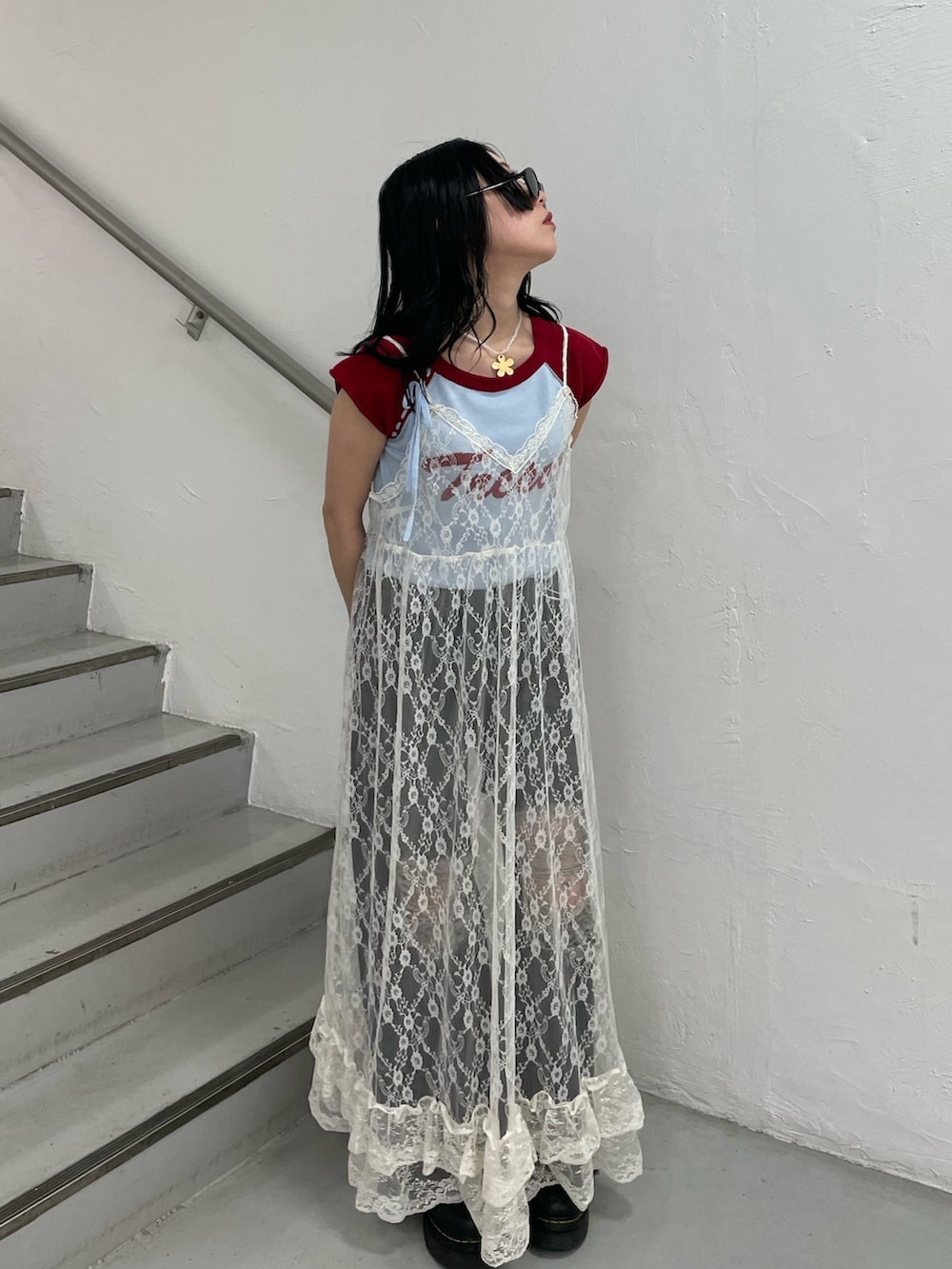 ブルー系のニット/セーター、ホワイト系のワンピース、ブラック系のデニムパンツを着用したレディースの春コーディネートの2枚目の写真