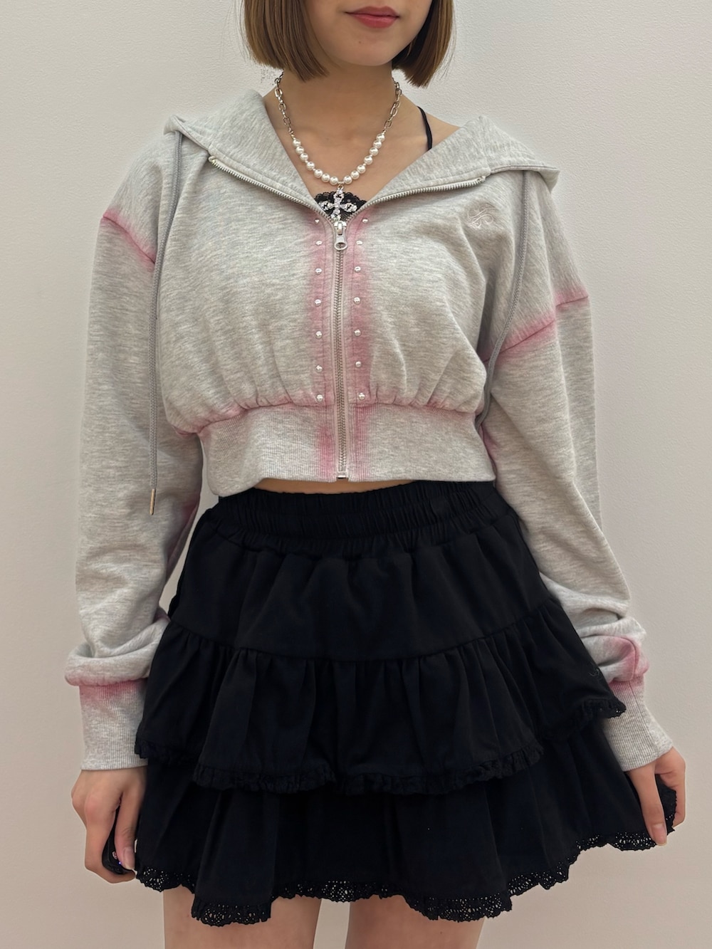 グレー系のパーカー、ブラック系のローファー、シルバー系のネックレスを着用したレディースの春コーディネートの6枚目の写真