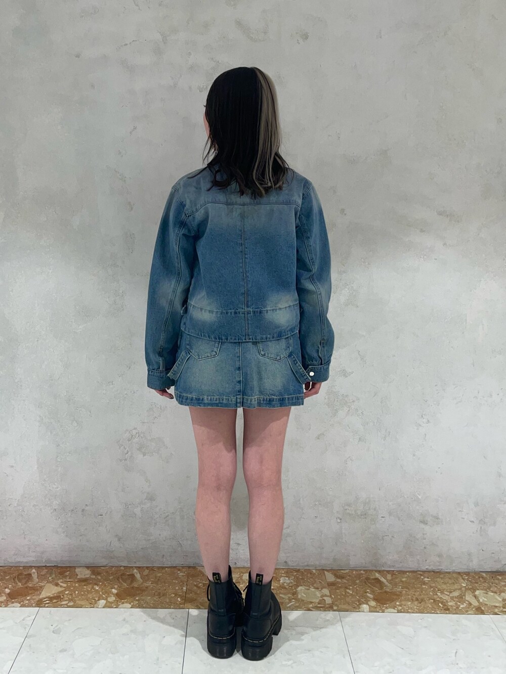 ブルー系のデニムスカート、ブルー系のニット/セーター、ブルー系のデニムジャケットを着用したレディースの冬コーディネートの3枚目の写真