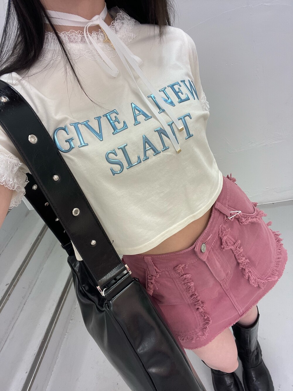 ピンク系のスカート、ホワイト系のTシャツ/カットソー、ブラック系のショルダーバッグを着用したレディースの春コーディネートの8枚目の写真