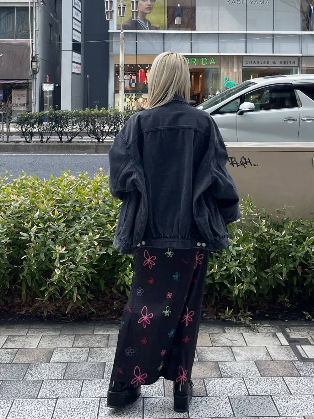 ブラック系のスカート、グリーン系のTシャツ/カットソー、ブラック系のデニムジャケットを着用したレディースの春コーディネートの5枚目の写真