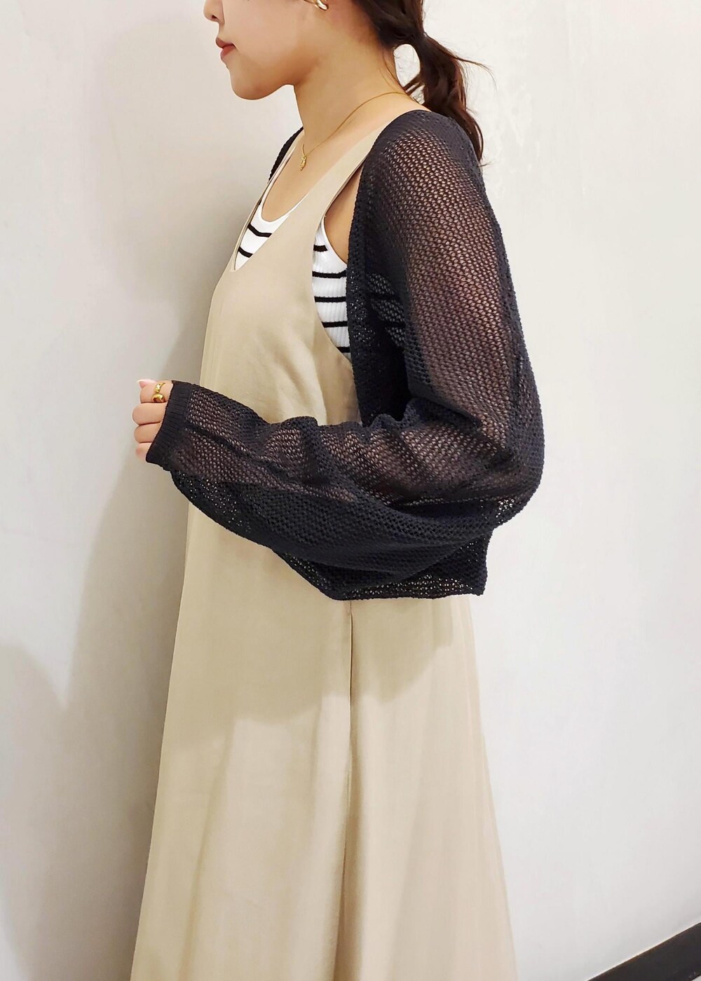 ブラック系のサンダル、ホワイト系のタンクトップ、ブラック系のハンドバッグを着用したレディースの春コーディネートの5枚目の写真