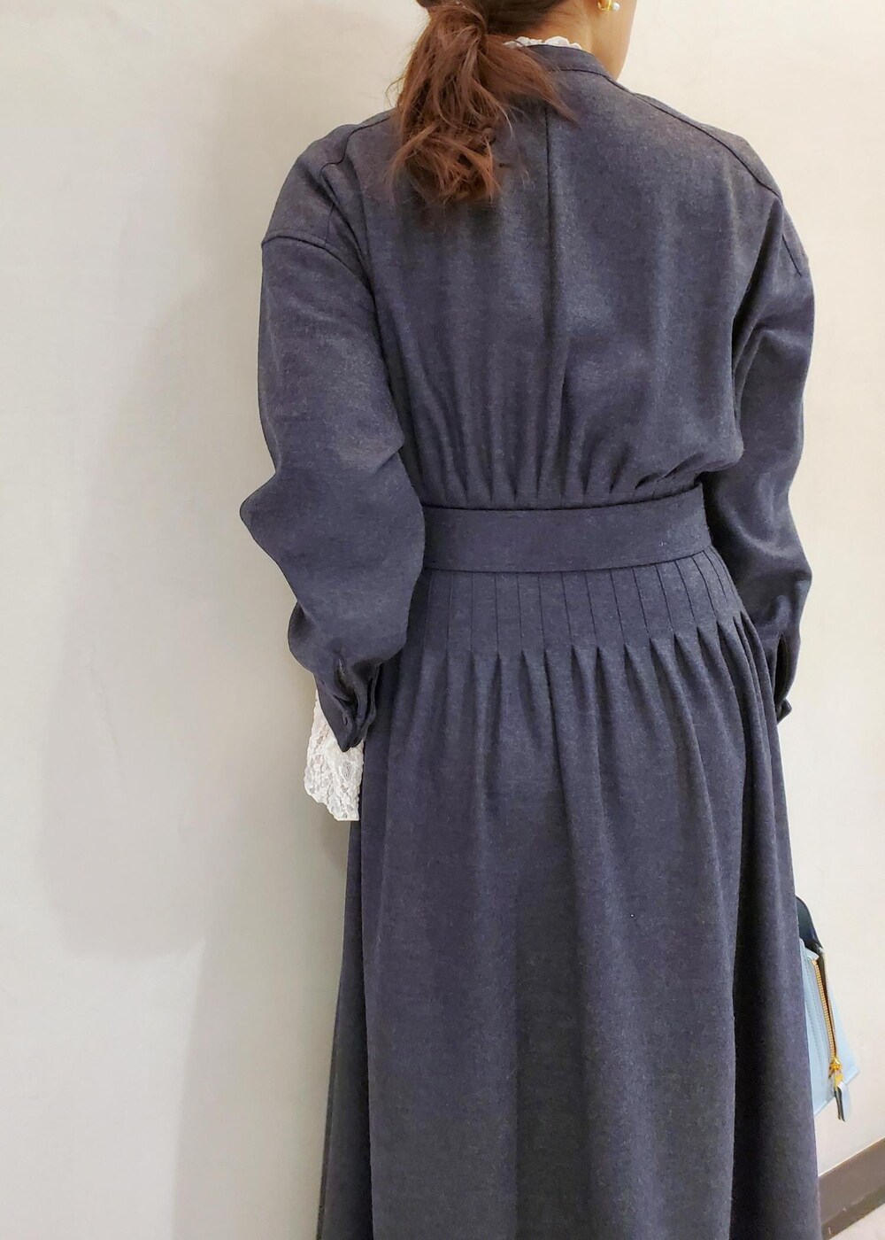 ブルー系のハンドバッグ、ブラック系のその他アウター、グレー系のワンピースを着用したレディースの冬コーディネートの8枚目の写真
