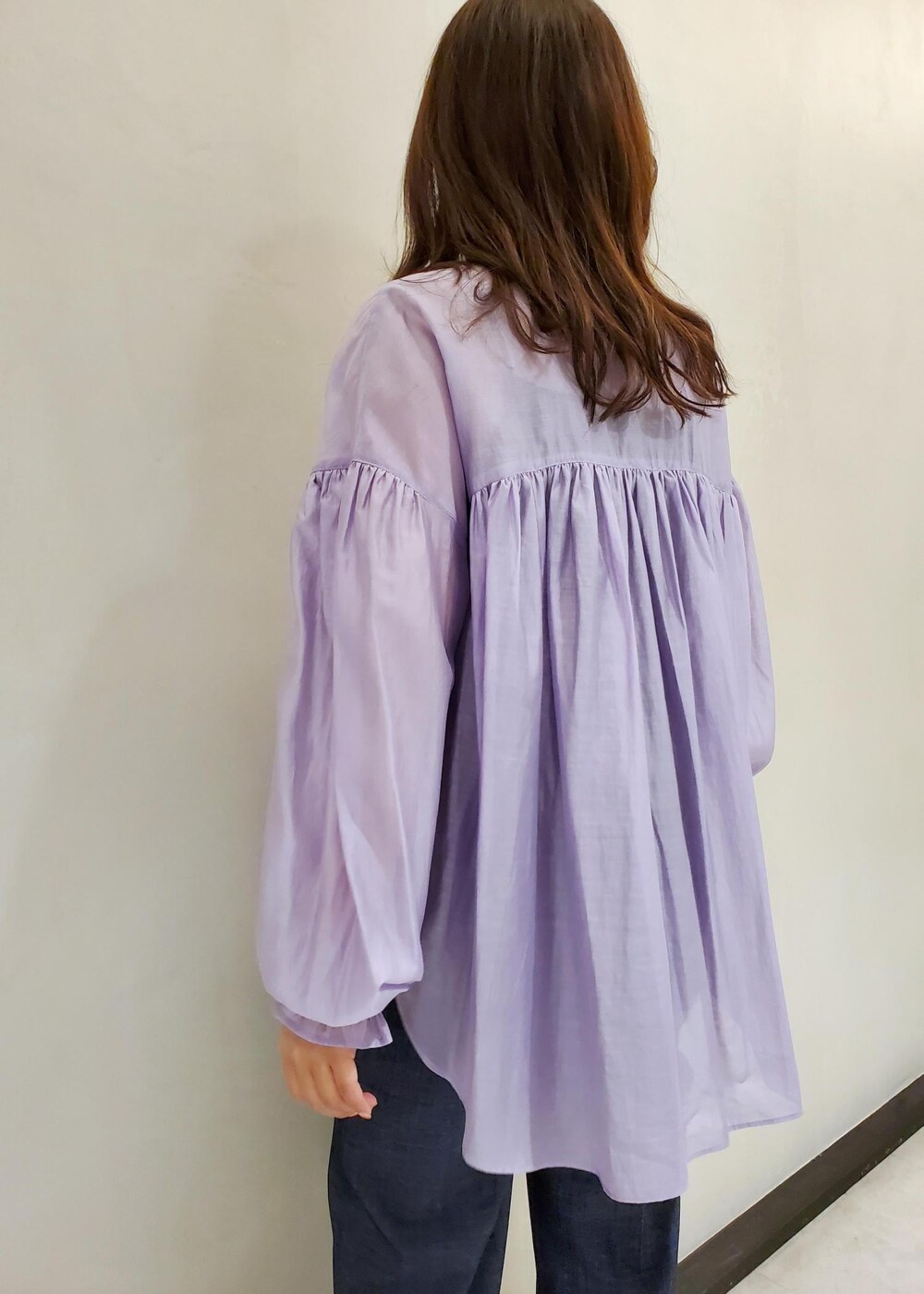 ブラック系のハンドバッグ、ブルー系のデニムパンツ、パープル系のシャツ/ブラウスを着用したレディースの冬コーディネートの5枚目の写真