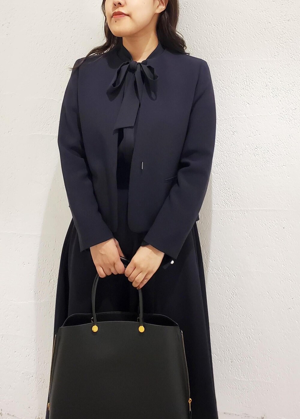 ブラック系のトートバッグ、ブラック系のパンプス、ブルー系のシャツ/ブラウスを着用したレディースの秋コーディネートの4枚目の写真