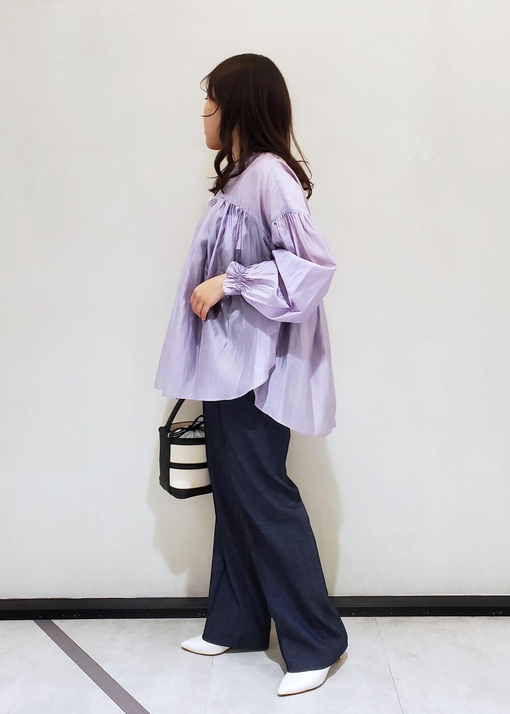 ブラック系のハンドバッグ、ブルー系のデニムパンツ、パープル系のシャツ/ブラウスを着用したレディースの冬コーディネートの2枚目の写真