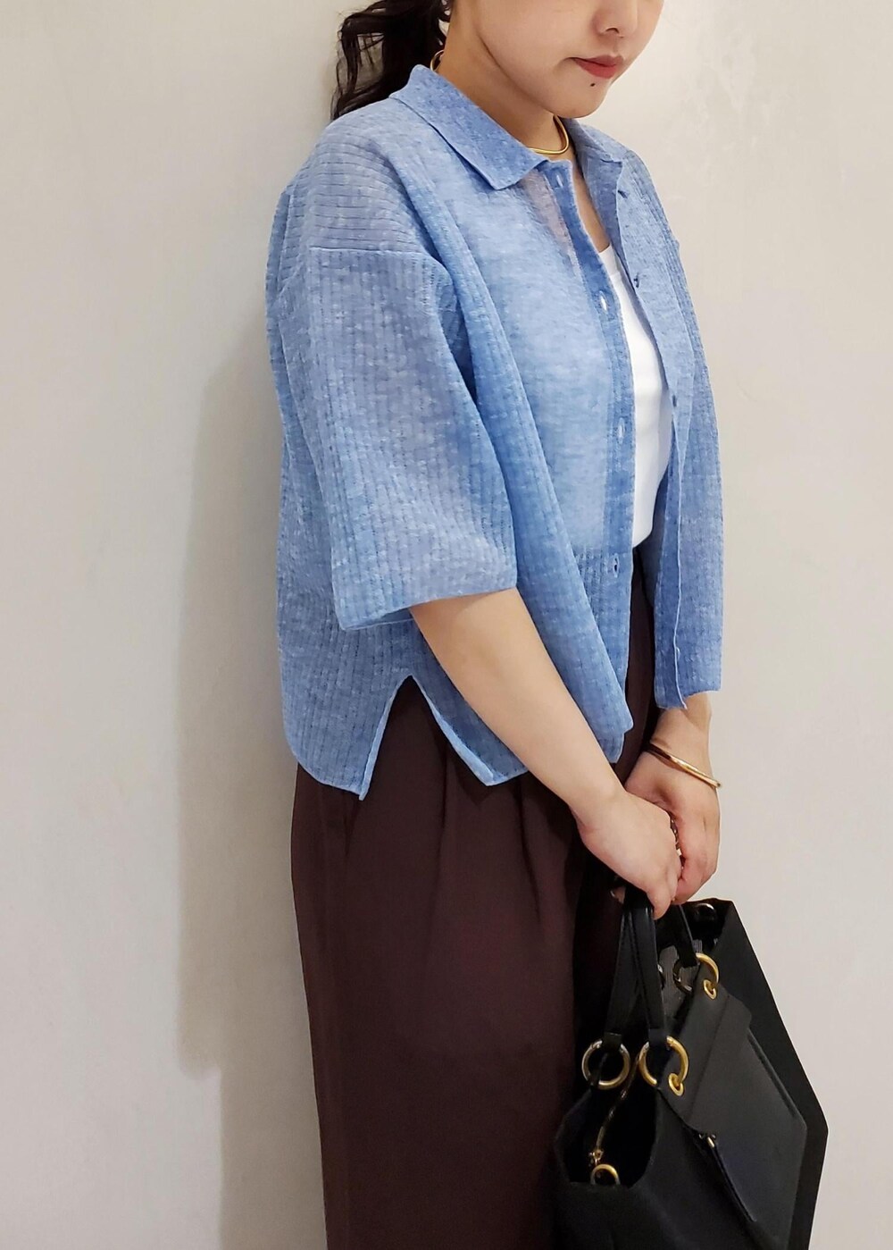 ブラック系のハンドバッグ、ブルー系のカーディガン/ボレロ、ホワイト系のタンクトップを着用したレディースの夏コーディネートの7枚目の写真