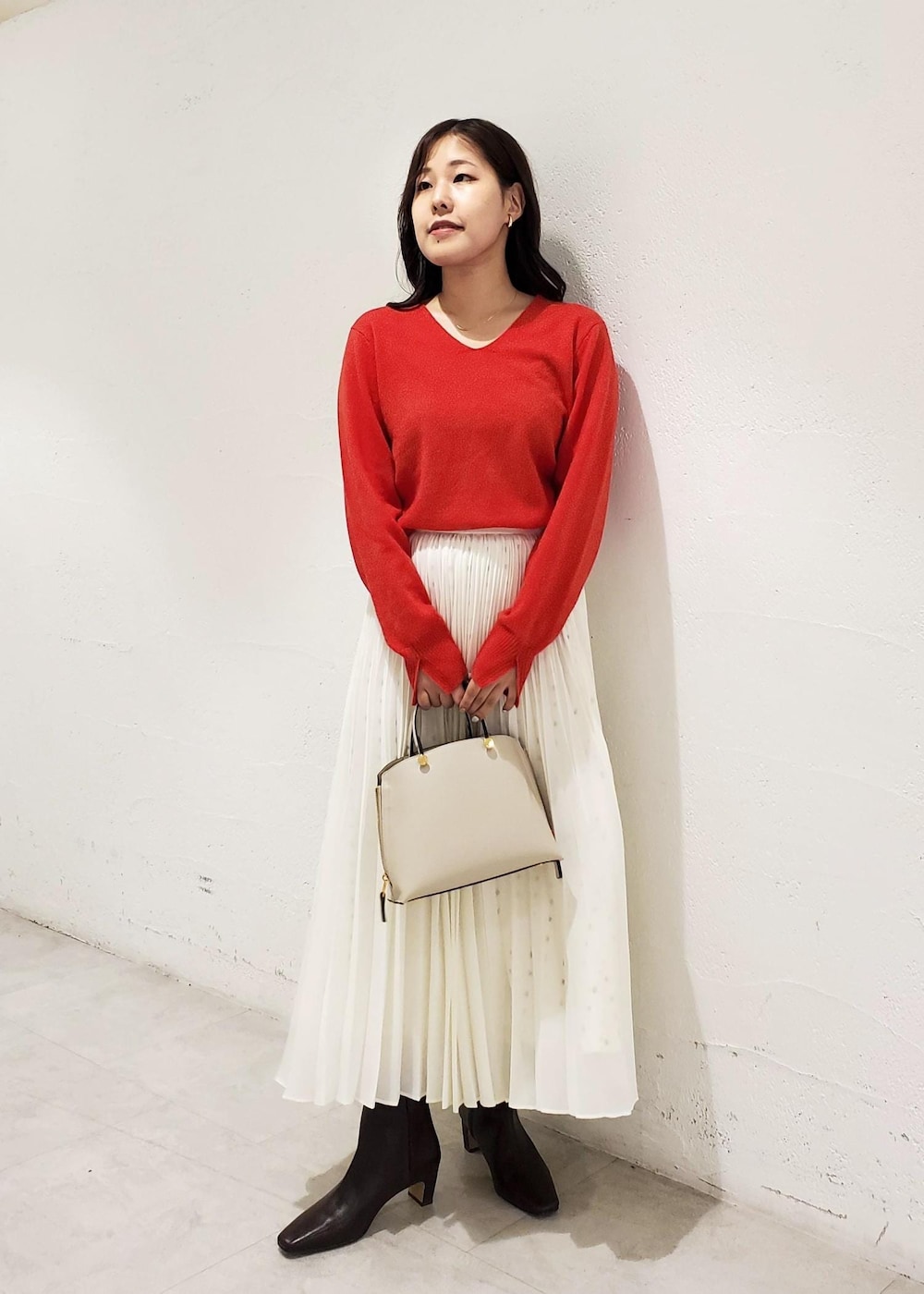 グレー系のハンドバッグ、ブラウン系のブーツ、ブラウン系のブルゾンを着用したレディースの秋コーディネートの4枚目の写真