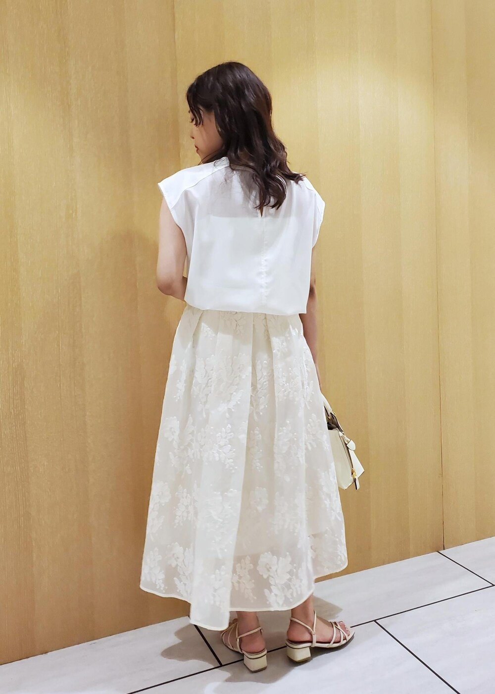 ホワイト系のハンドバッグ、ホワイト系のシャツ/ブラウス、ホワイト系のスカートを着用したレディースの春コーディネートの3枚目の写真