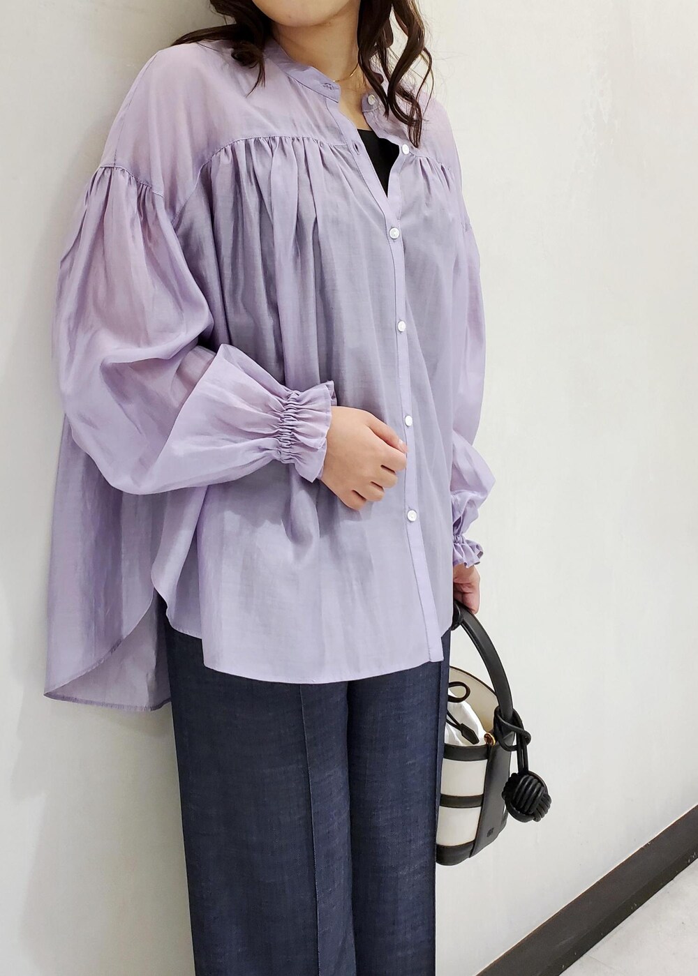 ブラック系のハンドバッグ、ブルー系のデニムパンツ、パープル系のシャツ/ブラウスを着用したレディースの冬コーディネートの4枚目の写真