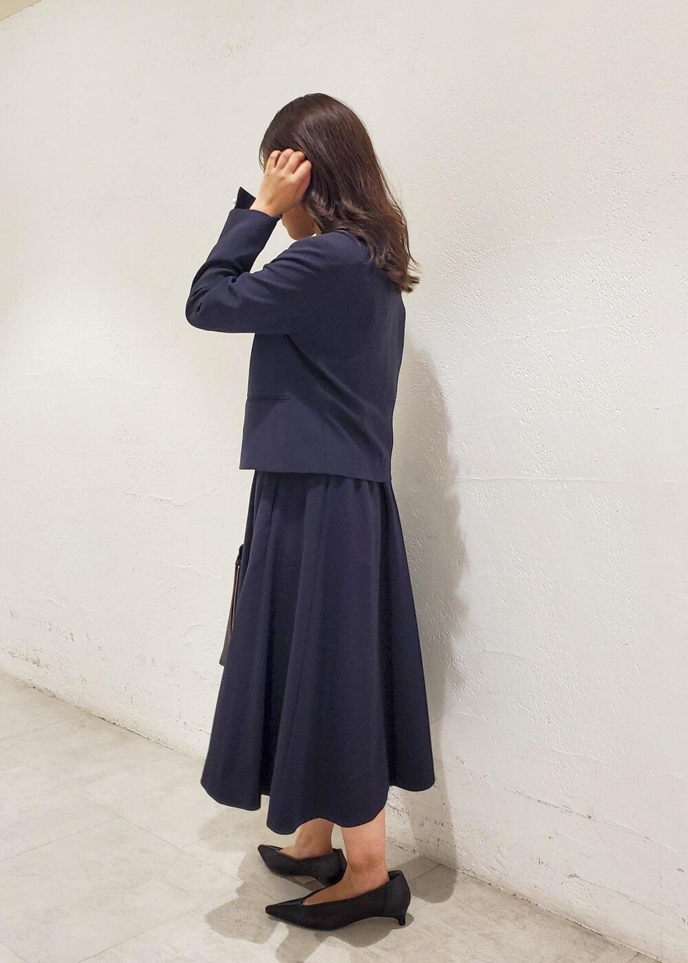 ブラック系のトートバッグ、ブラック系のパンプス、ブルー系のシャツ/ブラウスを着用したレディースの秋コーディネートの2枚目の写真