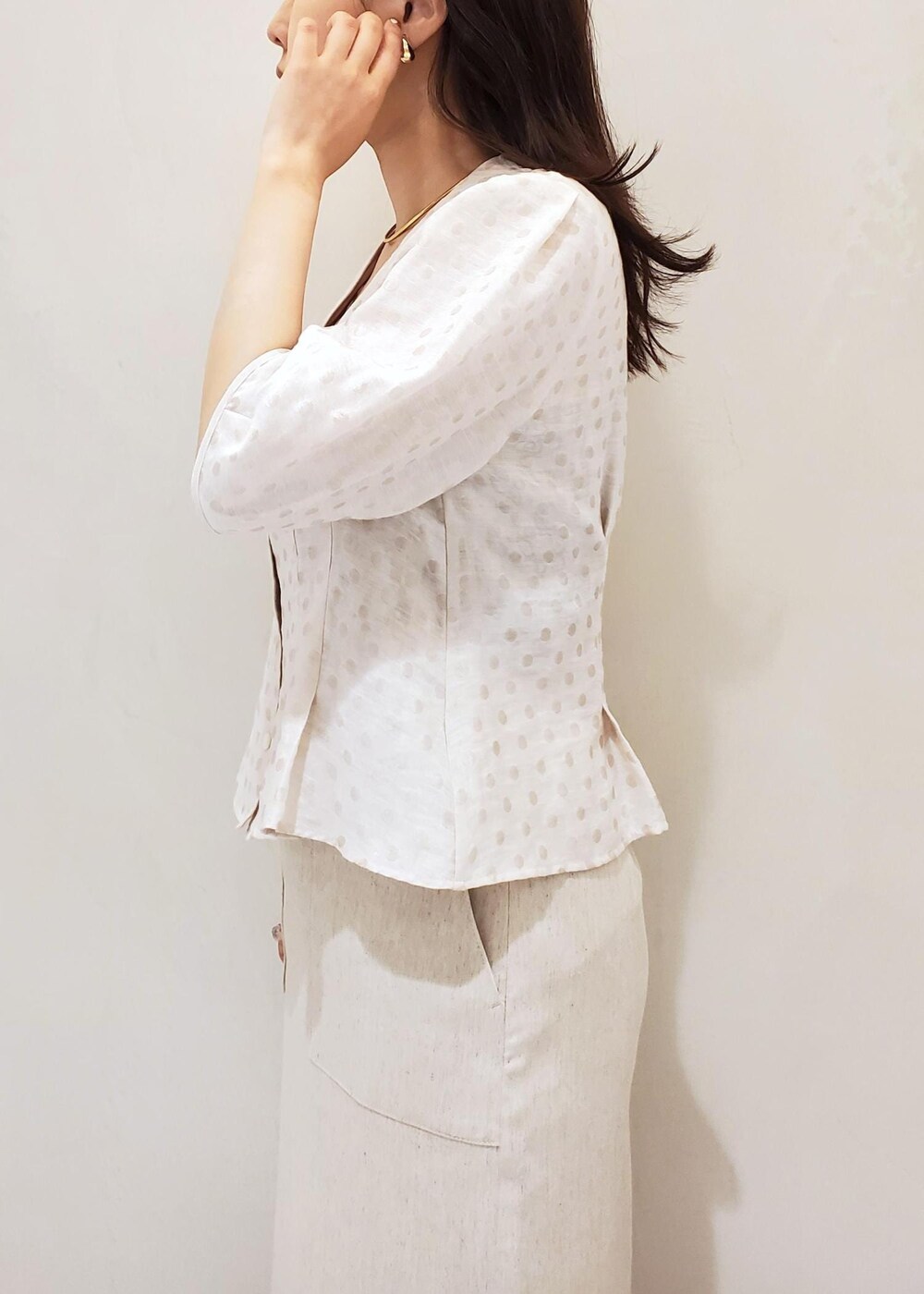 ブラック系のハンドバッグ、ブラック系のパンプス、ホワイト系のスカートを着用したレディースの夏コーディネートの6枚目の写真