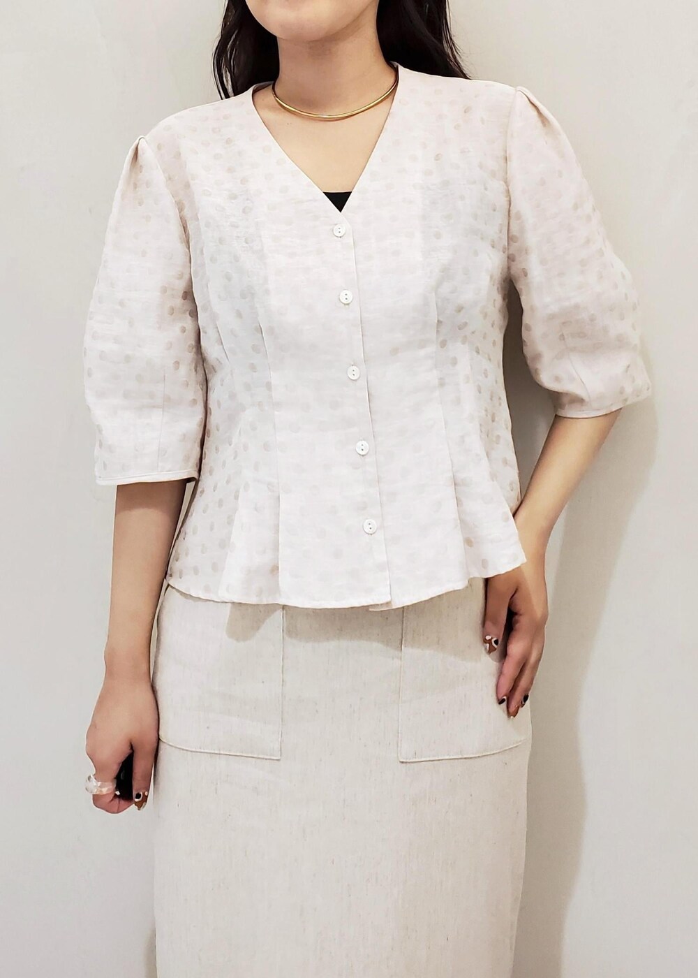 ブラック系のハンドバッグ、ブラック系のパンプス、ホワイト系のスカートを着用したレディースの夏コーディネートの4枚目の写真