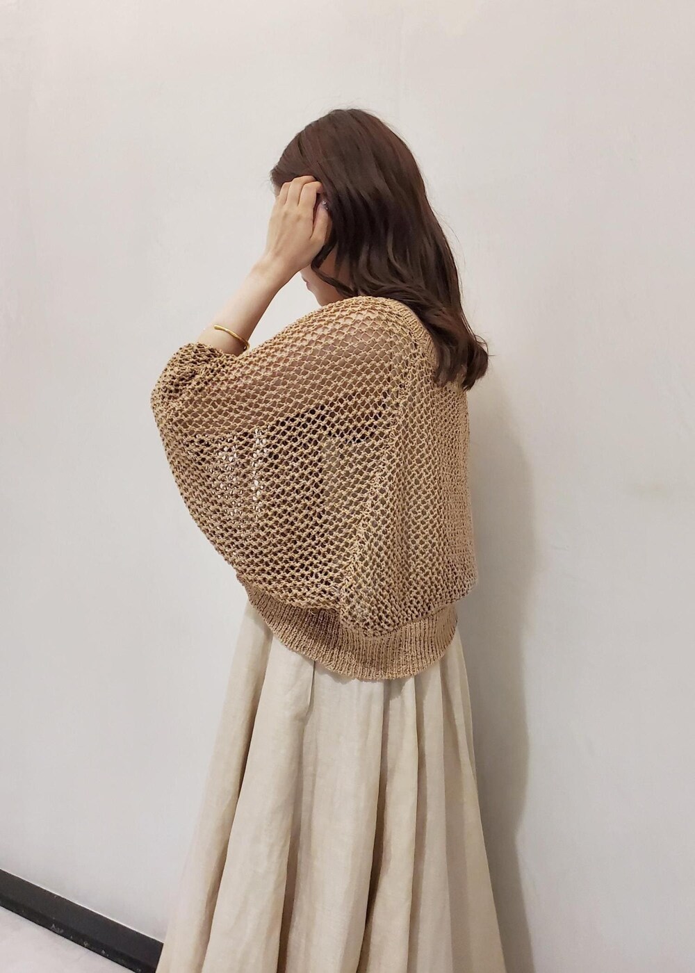 ホワイト系のハンドバッグ、ベージュ系のワンピース、ベージュ系のカーディガン/ボレロを着用したレディースの夏コーディネートの6枚目の写真