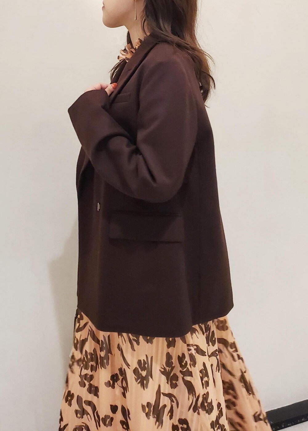 グレー系のハンドバッグ、ブラウン系のテーラードジャケット、オレンジ系のワンピースを着用したレディースの冬コーディネートの5枚目の写真