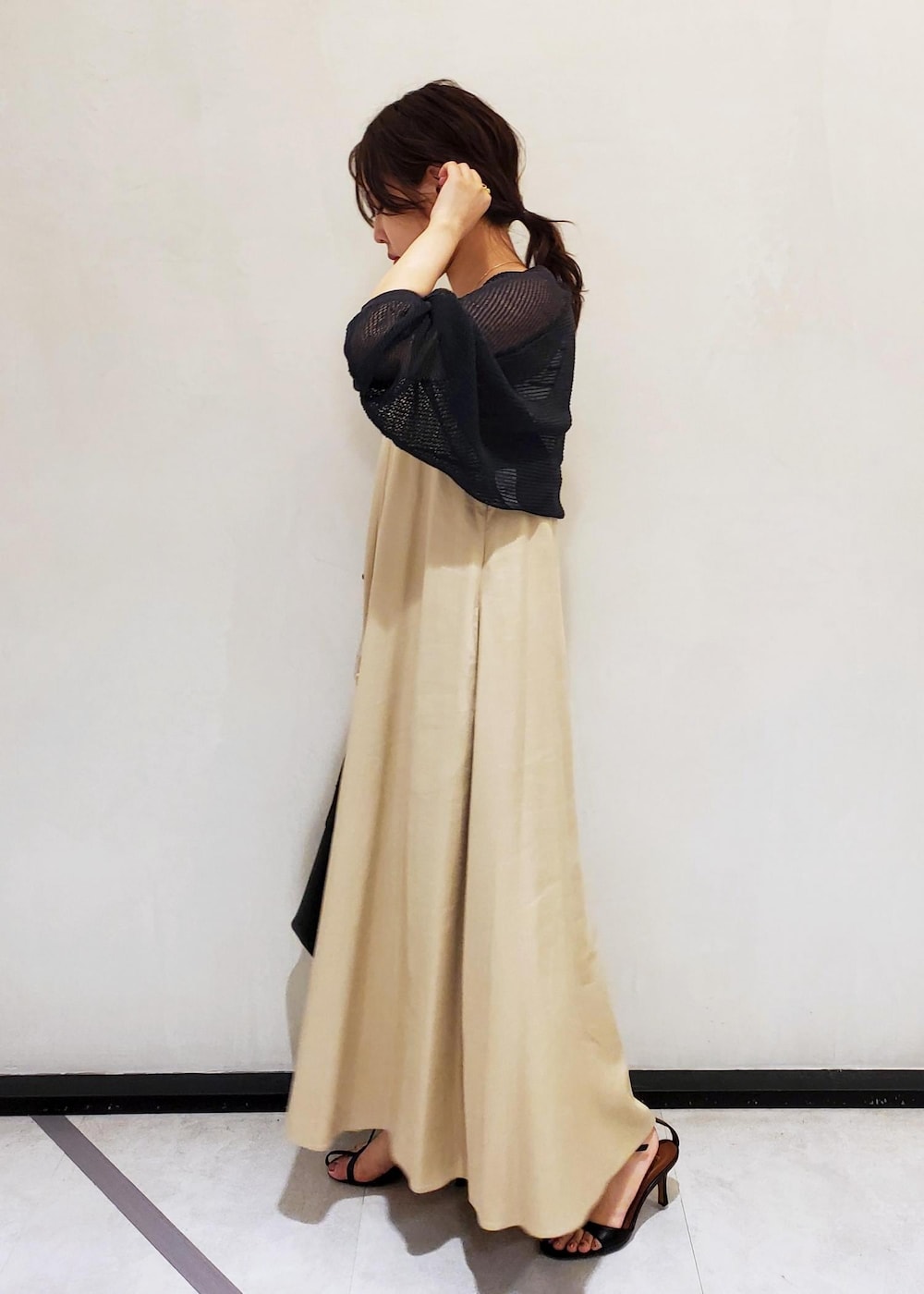 ブラック系のサンダル、ホワイト系のタンクトップ、ブラック系のハンドバッグを着用したレディースの春コーディネートの2枚目の写真