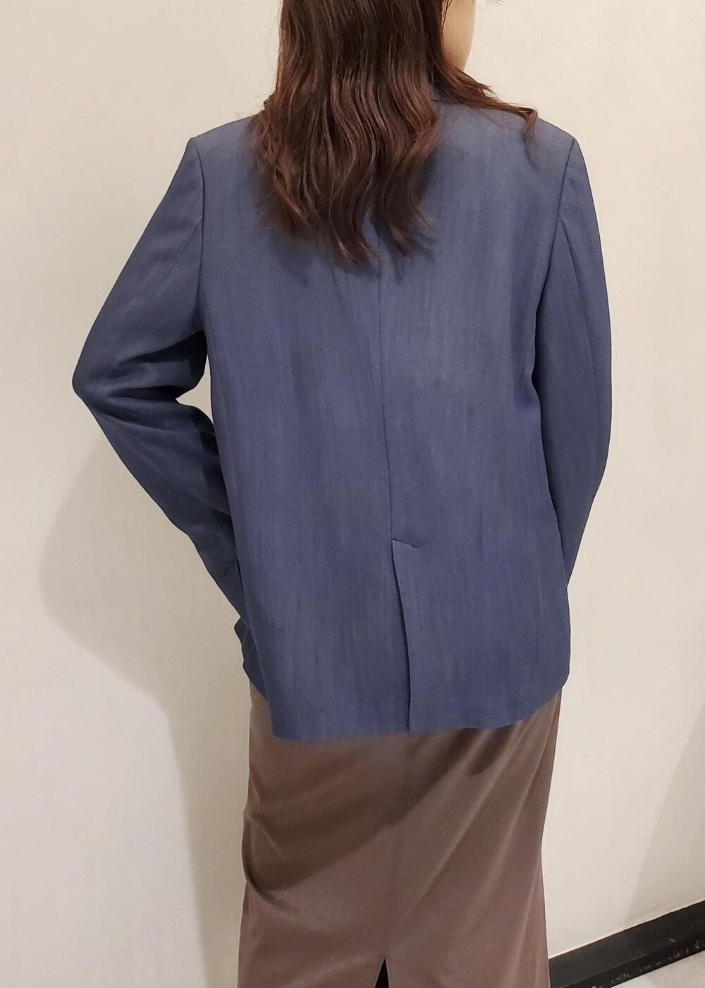 ブラック系のパンプス、ブルー系のテーラードジャケット、ブラック系のハンドバッグを着用したレディースの秋コーディネートの6枚目の写真