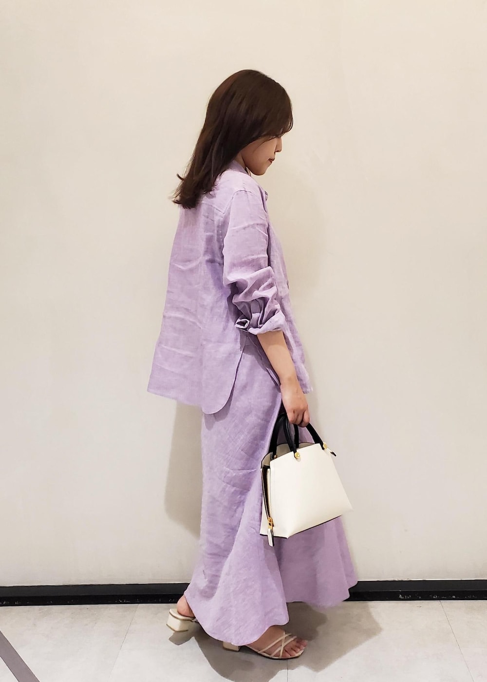 パープル系のスカート、パープル系のシャツ/ブラウス、ホワイト系のハンドバッグを着用したレディースの春コーディネートの4枚目の写真