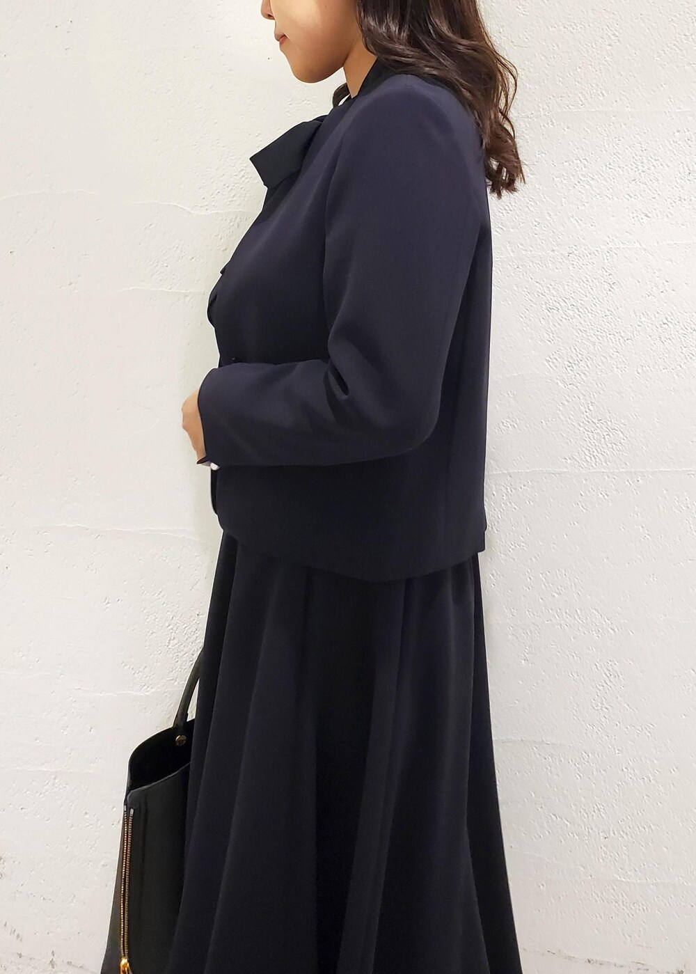 ブラック系のトートバッグ、ブラック系のパンプス、ブルー系のシャツ/ブラウスを着用したレディースの秋コーディネートの5枚目の写真