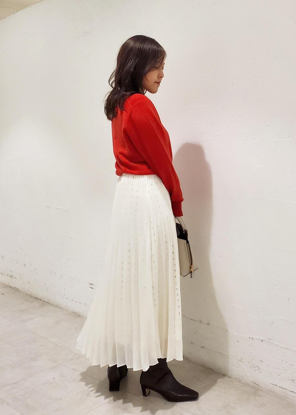 グレー系のハンドバッグ、ブラウン系のブーツ、ブラウン系のブルゾンを着用したレディースの秋コーディネートの5枚目の写真