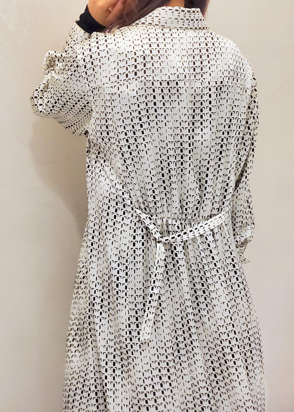 グリーン系のハンドバッグ、ホワイト系のスニーカー、ホワイト系のワンピースを着用したレディースの冬コーディネートの6枚目の写真