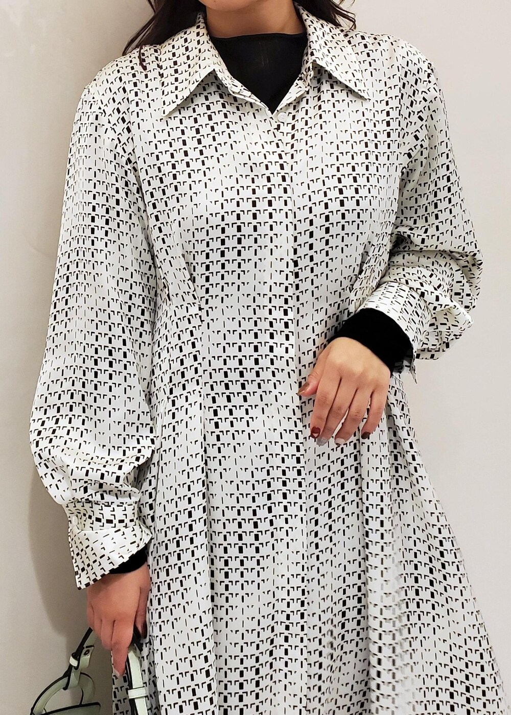 グリーン系のハンドバッグ、ホワイト系のスニーカー、ホワイト系のワンピースを着用したレディースの冬コーディネートの4枚目の写真