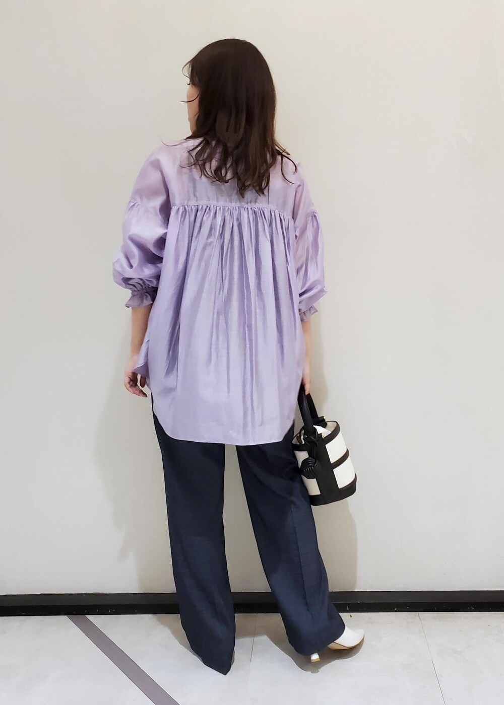 ブラック系のハンドバッグ、ブルー系のデニムパンツ、パープル系のシャツ/ブラウスを着用したレディースの冬コーディネートの3枚目の写真