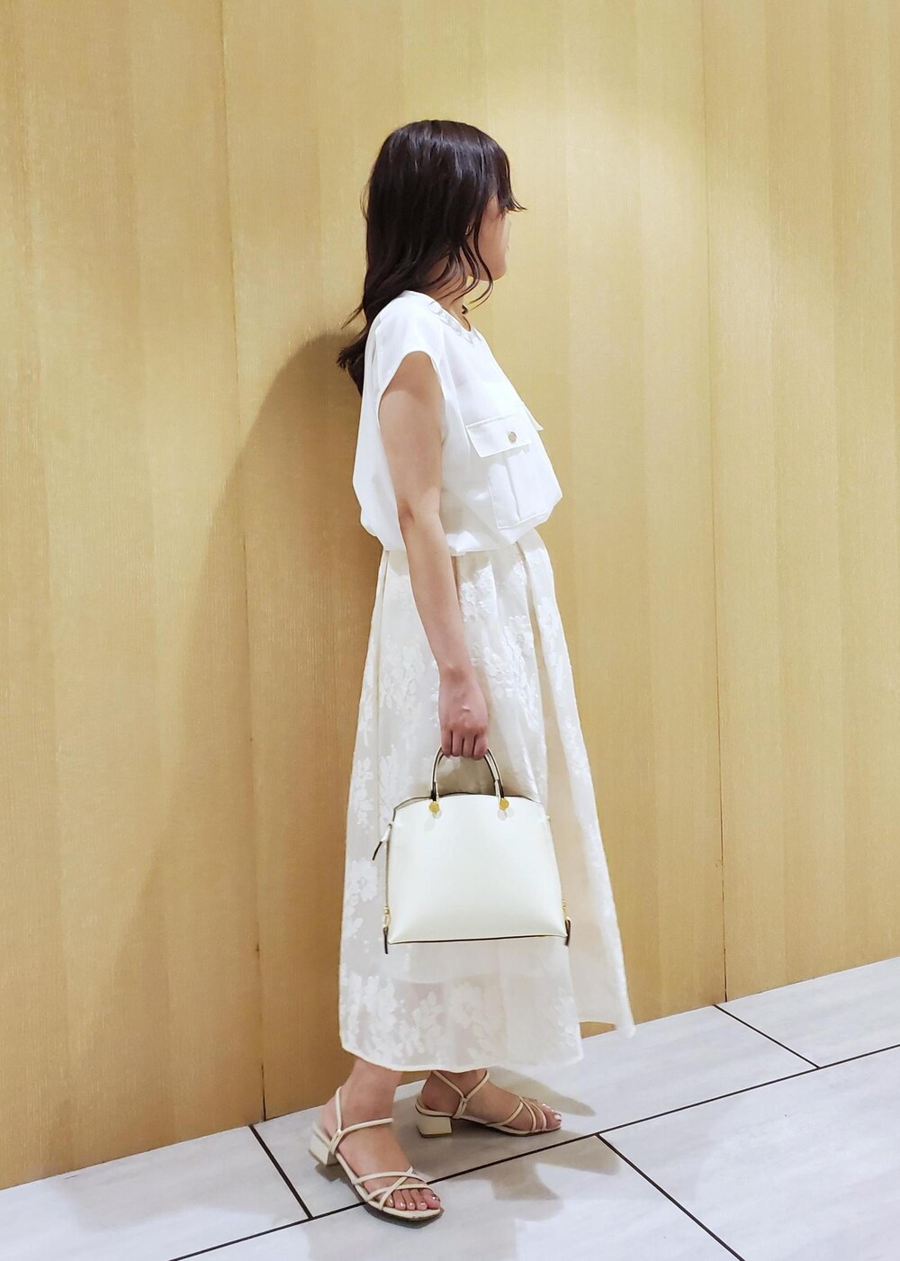 ホワイト系のハンドバッグ、ホワイト系のシャツ/ブラウス、ホワイト系のスカートを着用したレディースの春コーディネートの2枚目の写真