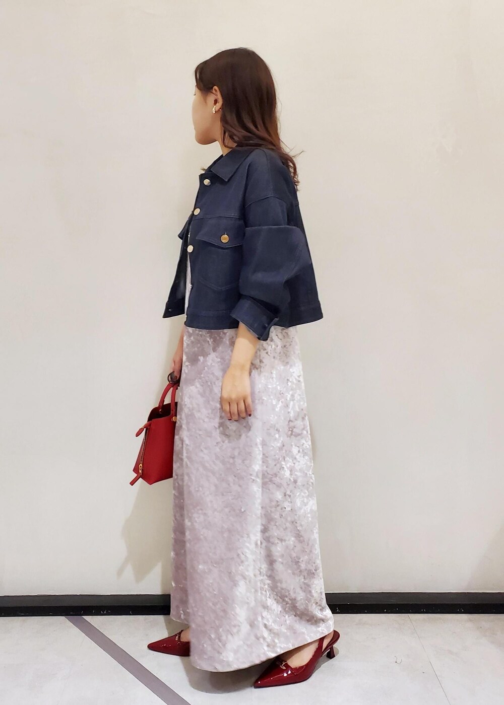 ホワイト系のキャミソール、レッド系のハンドバッグ、ホワイト系のワンピースを着用したレディースの秋コーディネートの2枚目の写真