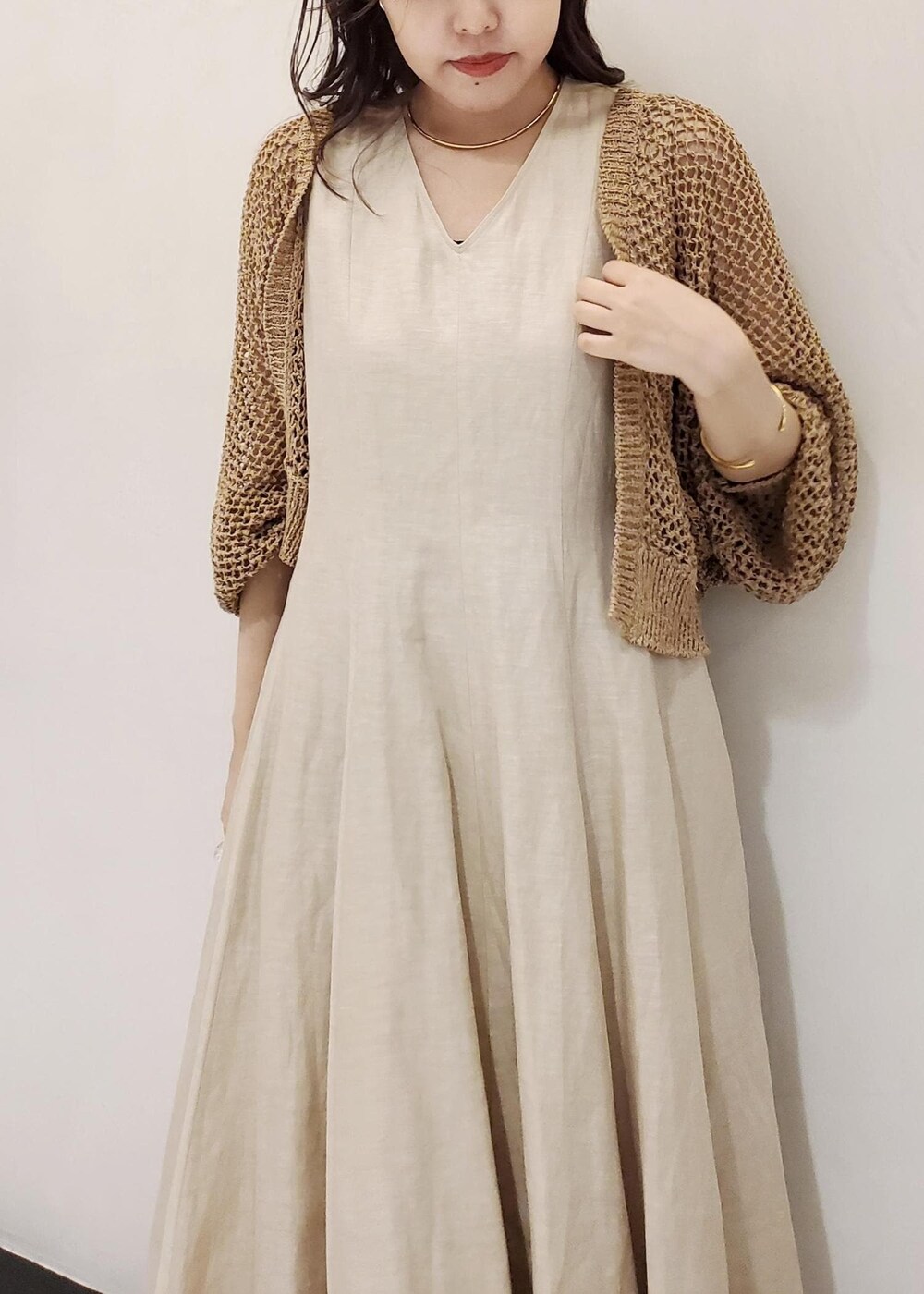 ホワイト系のハンドバッグ、ベージュ系のワンピース、ベージュ系のカーディガン/ボレロを着用したレディースの夏コーディネートの5枚目の写真