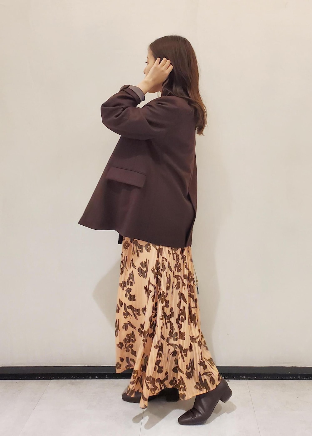 グレー系のハンドバッグ、ブラウン系のテーラードジャケット、オレンジ系のワンピースを着用したレディースの冬コーディネートの2枚目の写真