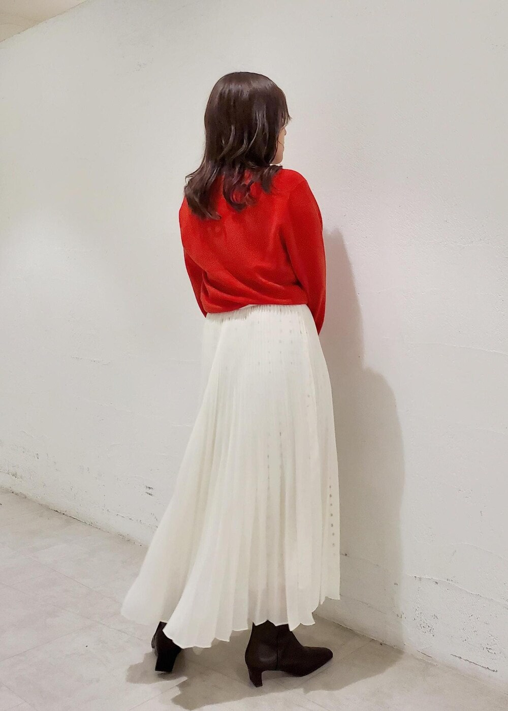 グレー系のハンドバッグ、ブラウン系のブーツ、ブラウン系のブルゾンを着用したレディースの秋コーディネートの6枚目の写真