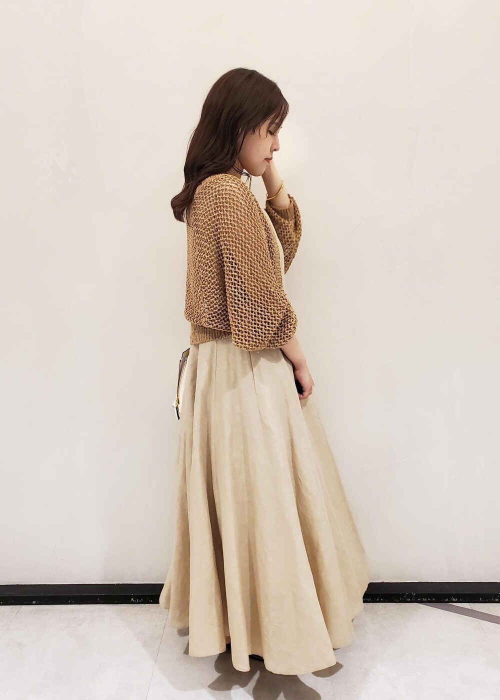 ホワイト系のハンドバッグ、ベージュ系のワンピース、ベージュ系のカーディガン/ボレロを着用したレディースの夏コーディネートの4枚目の写真