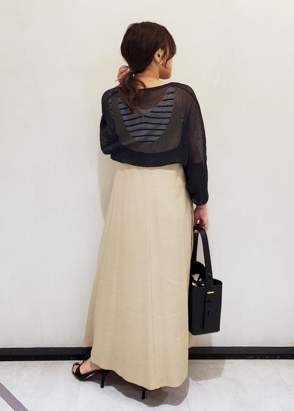 ブラック系のサンダル、ホワイト系のタンクトップ、ブラック系のハンドバッグを着用したレディースの春コーディネートの3枚目の写真