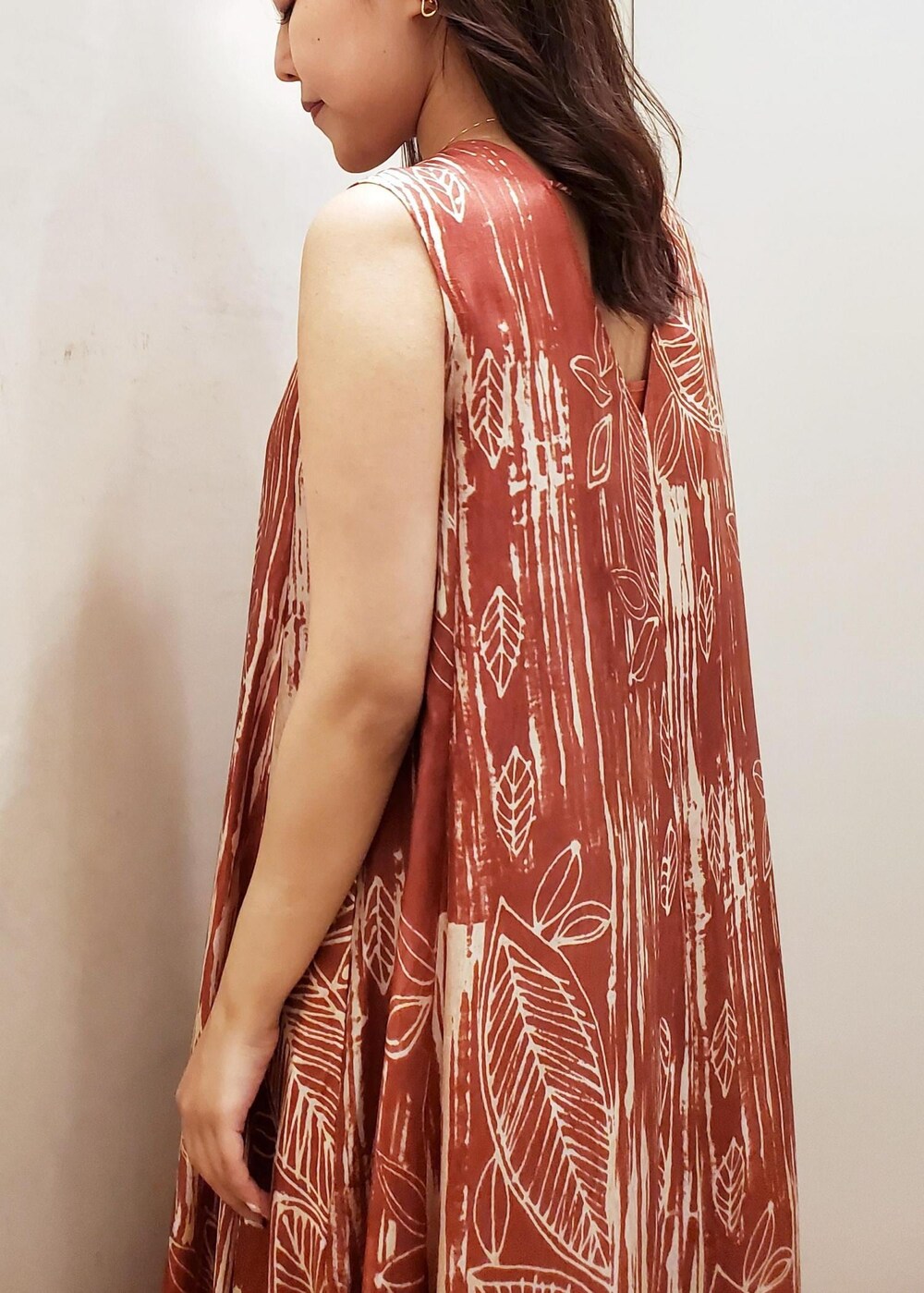 ブラウン系のワンピース、ホワイト系のショルダーバッグ、ゴールド系のネックレスを着用したレディースの夏コーディネートの4枚目の写真