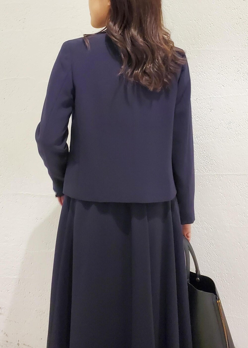 ブラック系のトートバッグ、ブラック系のパンプス、ブルー系のシャツ/ブラウスを着用したレディースの秋コーディネートの6枚目の写真