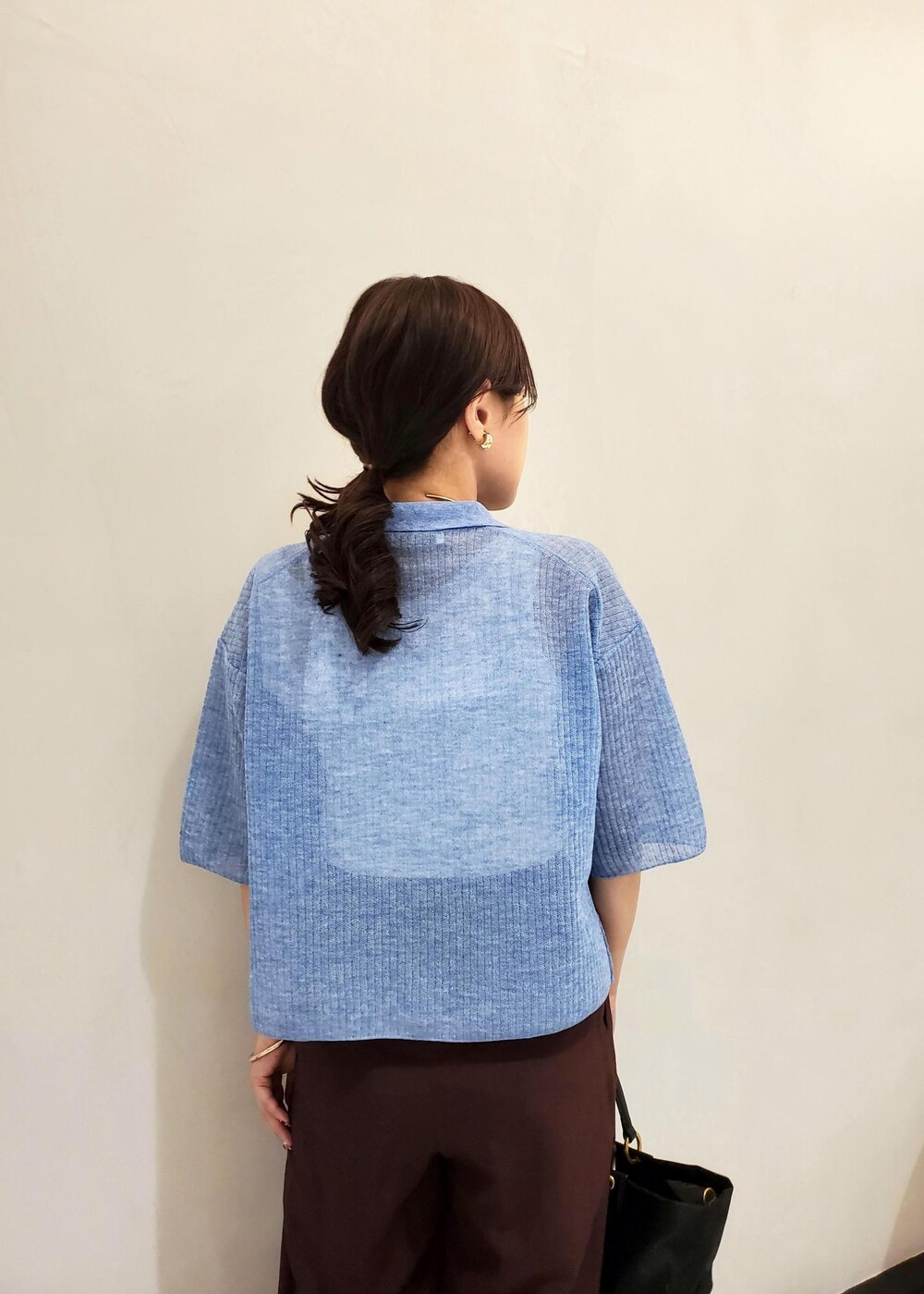 ブラック系のハンドバッグ、ブルー系のカーディガン/ボレロ、ホワイト系のタンクトップを着用したレディースの夏コーディネートの6枚目の写真