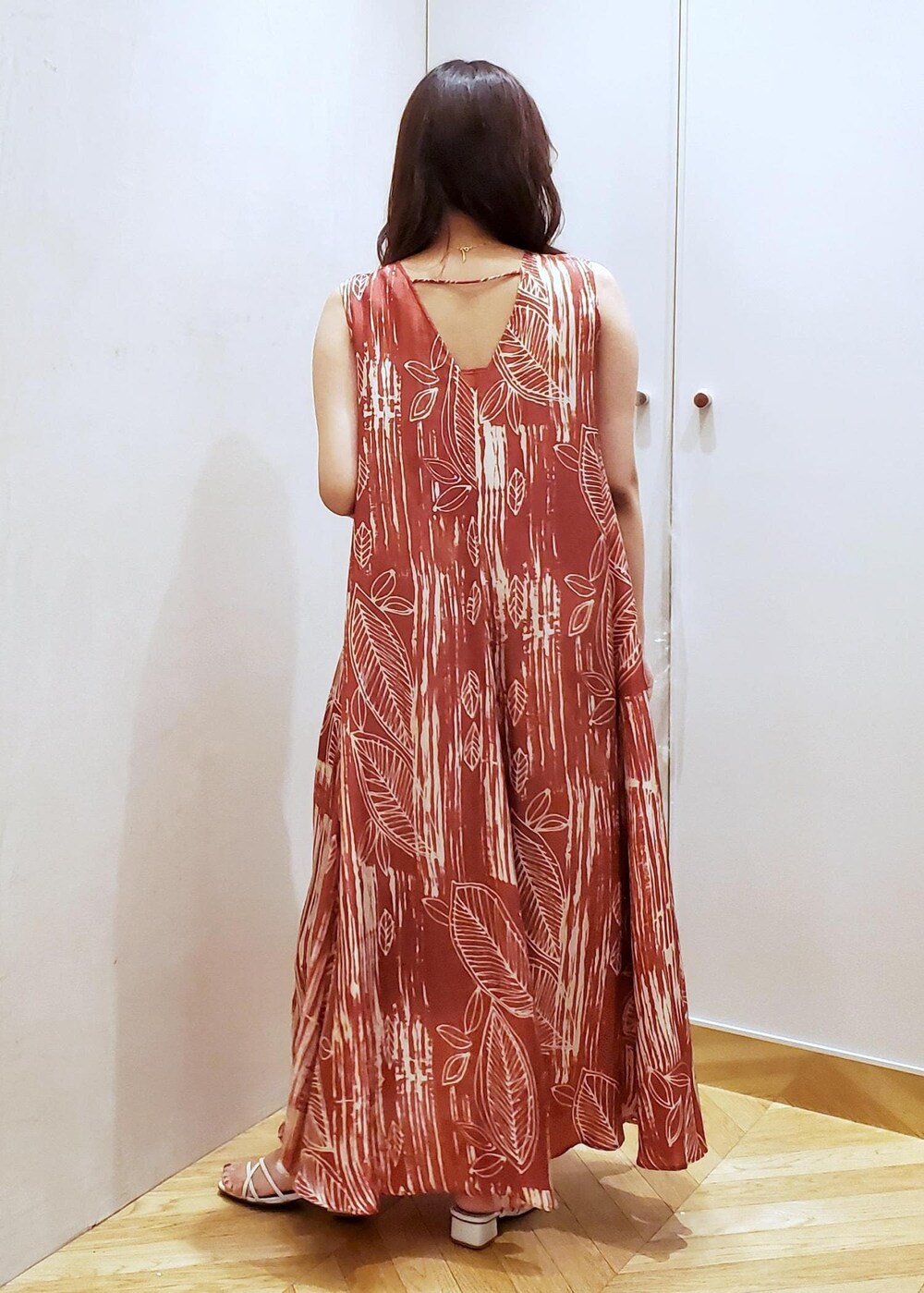 ブラウン系のワンピース、ホワイト系のショルダーバッグ、ゴールド系のネックレスを着用したレディースの夏コーディネートの3枚目の写真