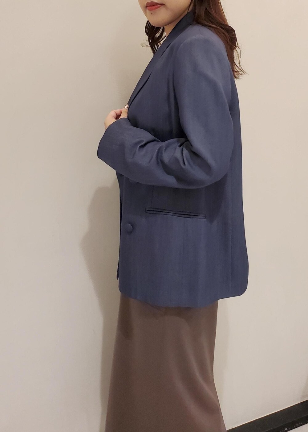 ブラック系のパンプス、ブルー系のテーラードジャケット、ブラック系のハンドバッグを着用したレディースの秋コーディネートの5枚目の写真