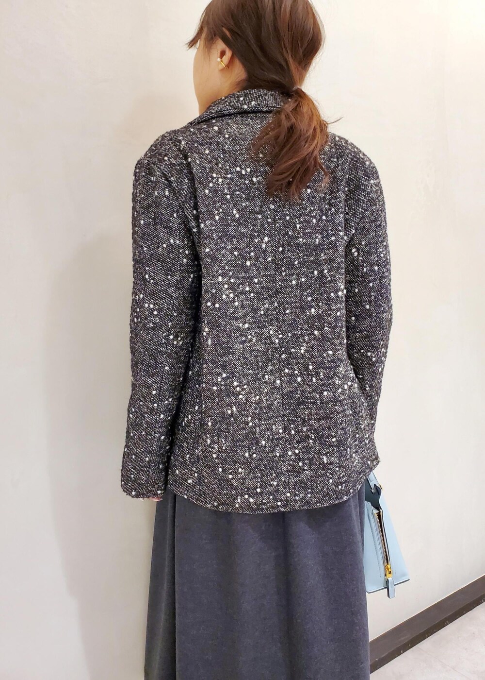ブルー系のハンドバッグ、ブラック系のその他アウター、グレー系のワンピースを着用したレディースの冬コーディネートの5枚目の写真