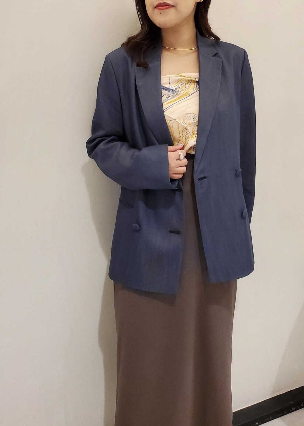 ブラック系のパンプス、ブルー系のテーラードジャケット、ブラック系のハンドバッグを着用したレディースの秋コーディネートの4枚目の写真