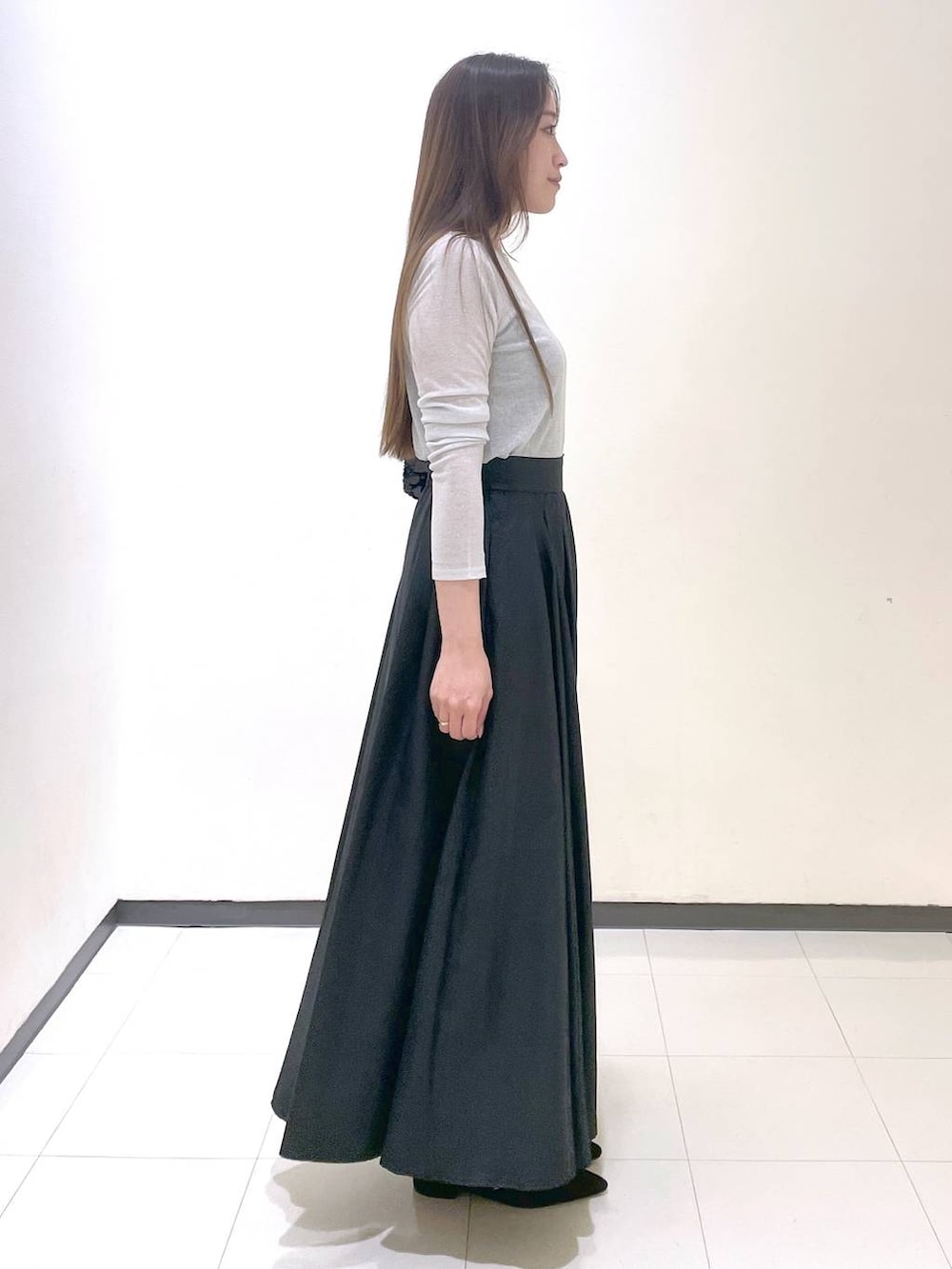 ブラック系のパンプス、ブラック系のトートバッグ、グレー系のTシャツ/カットソーを着用したレディースの秋コーディネートの2枚目の写真