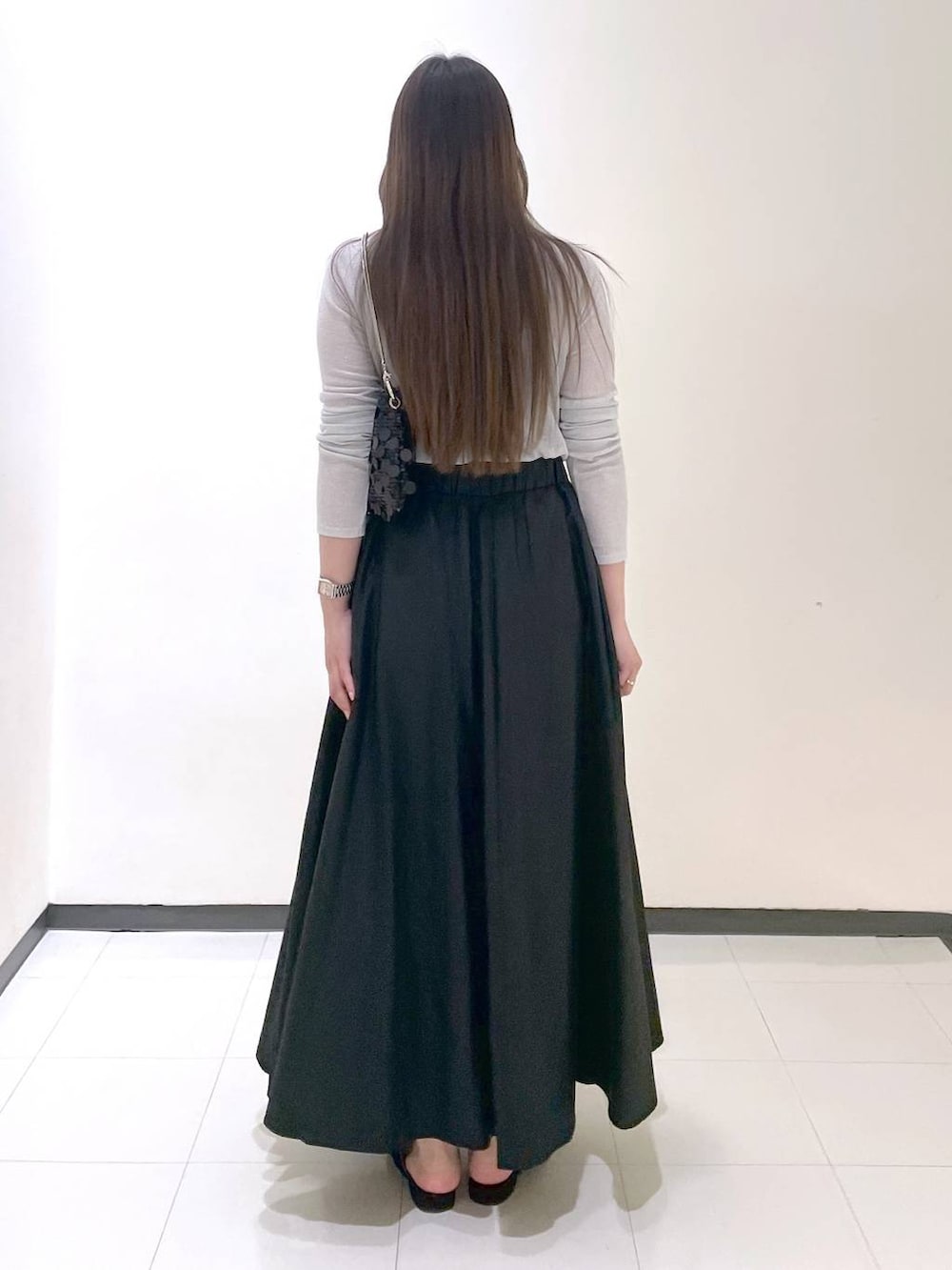 ブラック系のパンプス、ブラック系のトートバッグ、グレー系のTシャツ/カットソーを着用したレディースの秋コーディネートの3枚目の写真